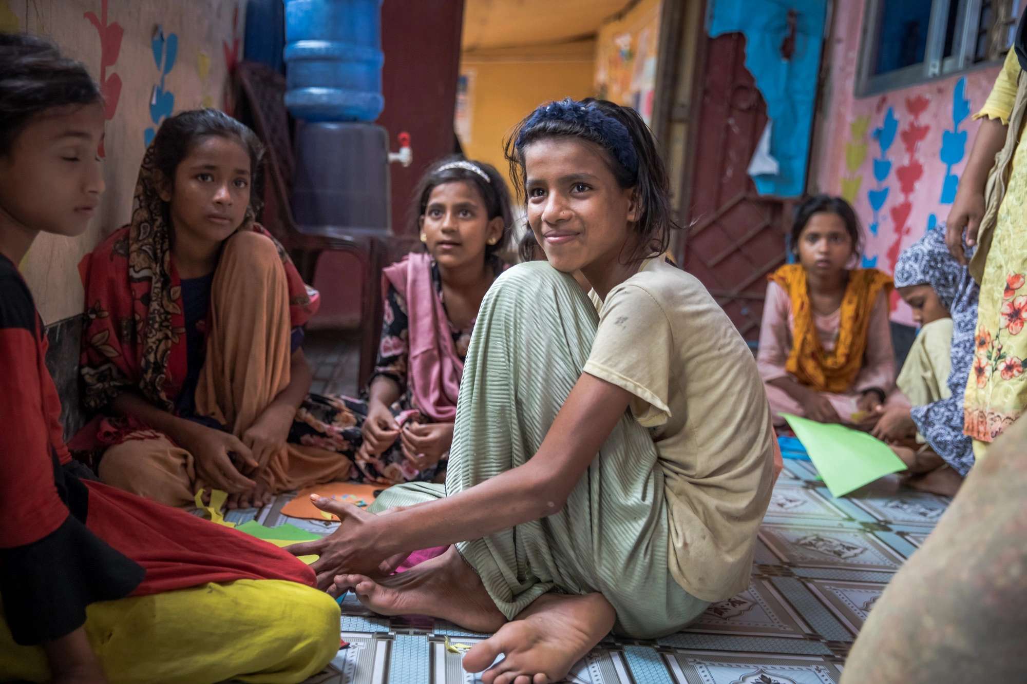 A Rohingya girl sitting in a circle in class.